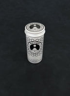 Silver metal storage tin with black patterned design for beeswax tealights on a dark background
