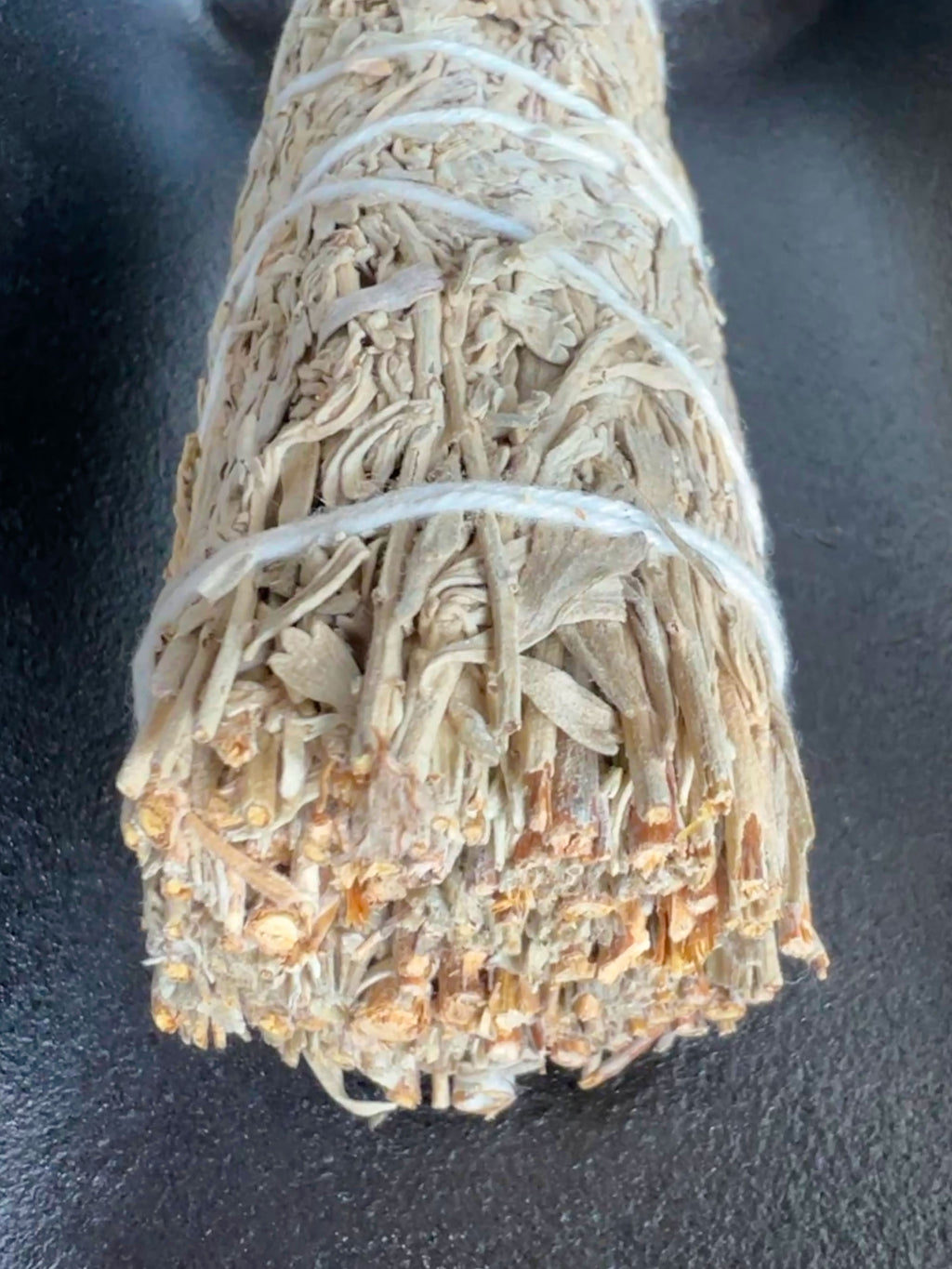 Blue Sage bundled with white cotton string on a dark background