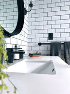 Cast iron incense burner and acacia wood tray set holding a bundle of Eucalyptus tied with white cotton string on a white countertop in a styled living room