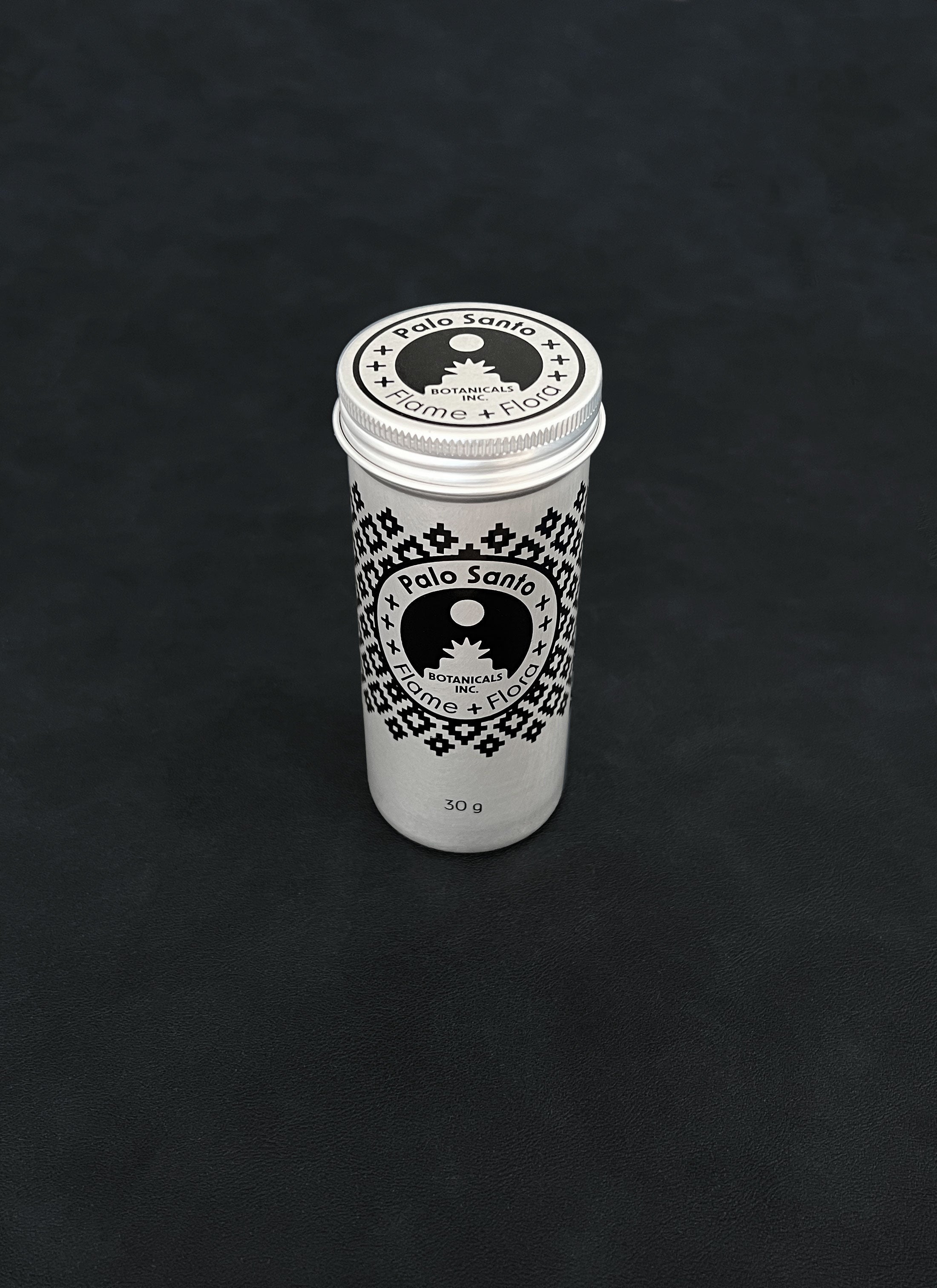 Silver metal storage tin with black patterned design for palo santo on a dark background