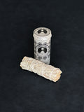 White Sage storage tin with black patterned design and a bundle of White Sage tied with white cotton string displayed in the foreground on a dark background