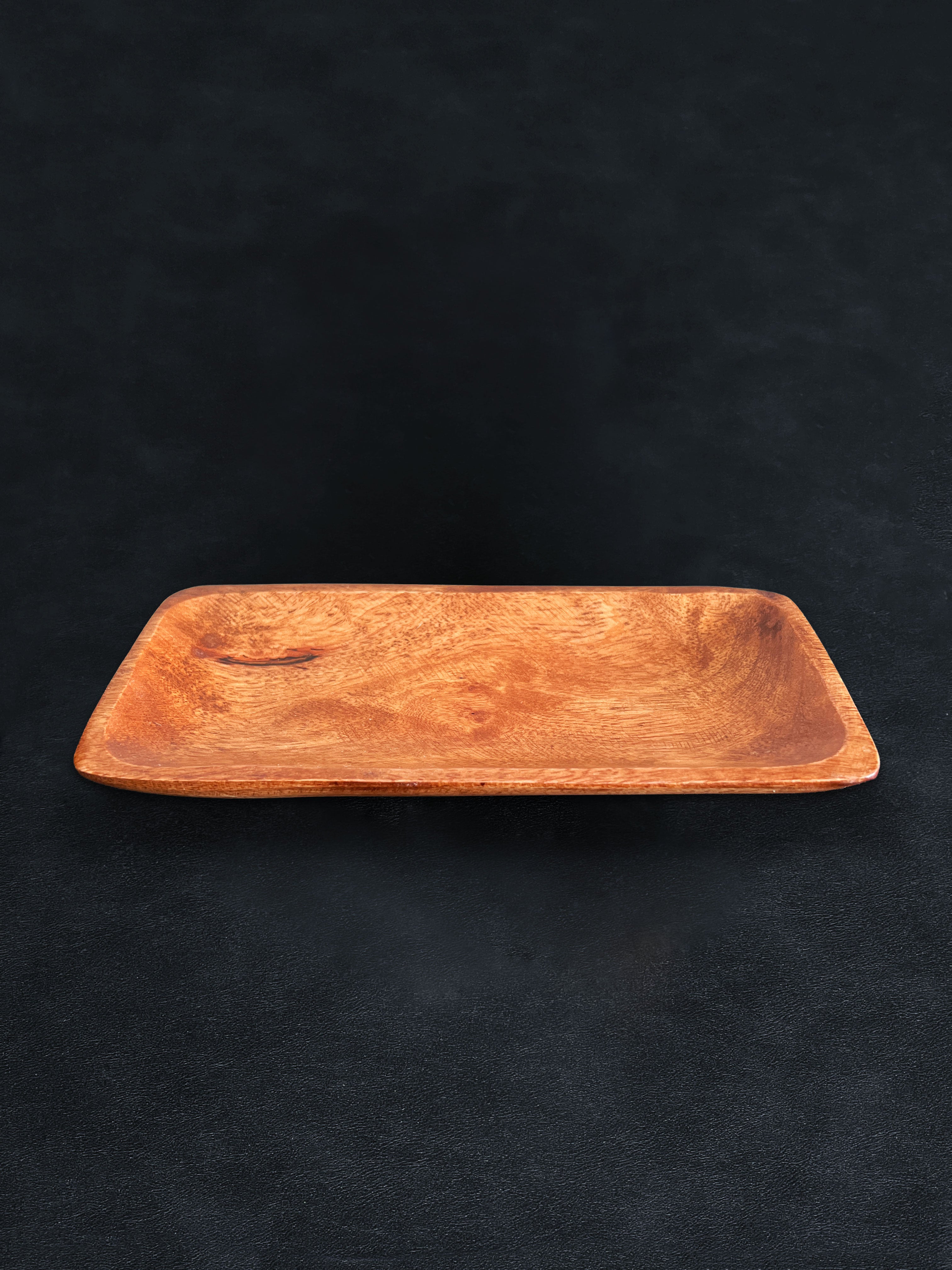 Bird’s-eye view of a rectangular acacia wood tray positioned horizontally against a dark background